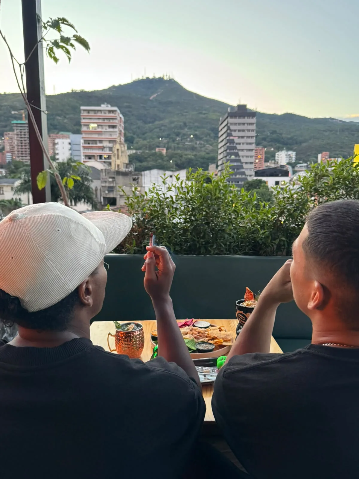 Dos visitantes comparten comida y conversación en la terraza de Arabba